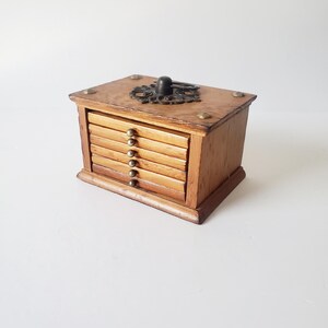 May include: Wooden coaster set with a decorative metal top. The set has six coasters and a wooden box with a hinged lid.