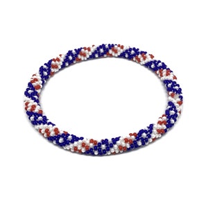 May include: A red, white, and blue beaded bracelet with a spiral pattern.