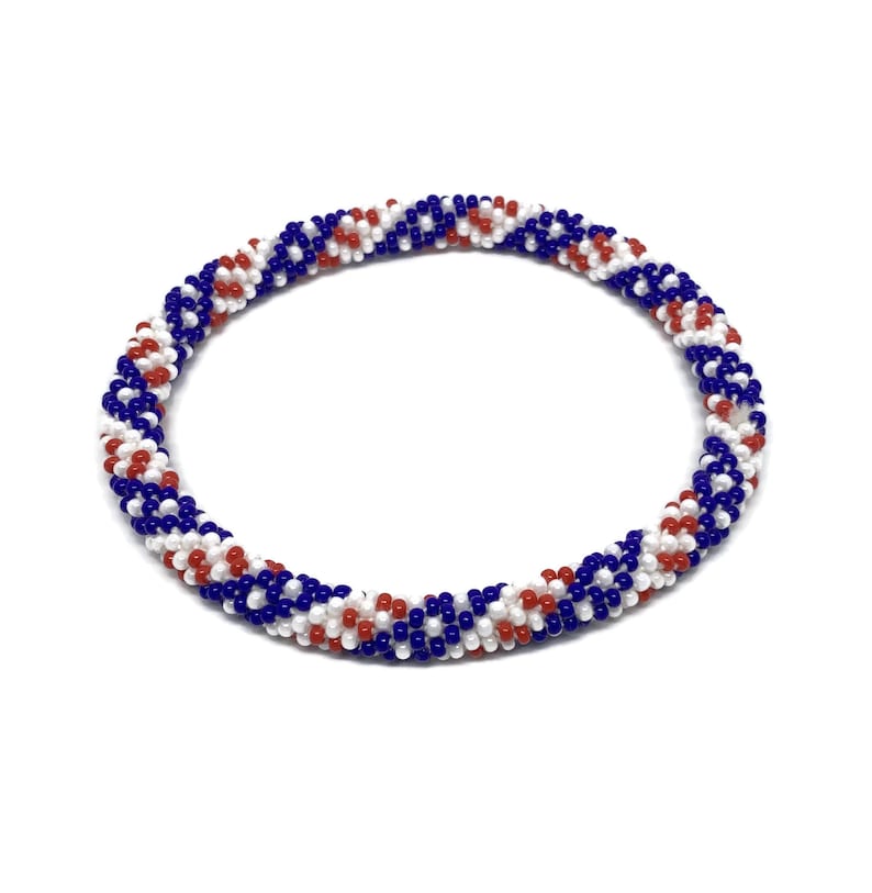 May include: A red, white, and blue beaded bracelet with a spiral pattern.