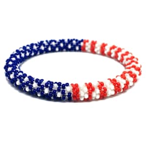 May include: A beaded bracelet with red, white, and blue beads arranged in a pattern resembling the American flag.