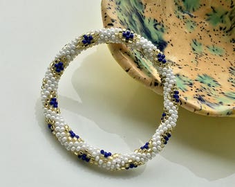 Bracelets de perles du Népal faits main par Ramila. Blanc avec or et diamant bleu.