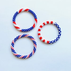 Puede incluir: Tres pulseras de cuentas en colores rojo, blanco y azul. Las pulseras est&aacute;n hechas de cuentas peque&ntilde;as y est&aacute;n tejidas en espiral.
