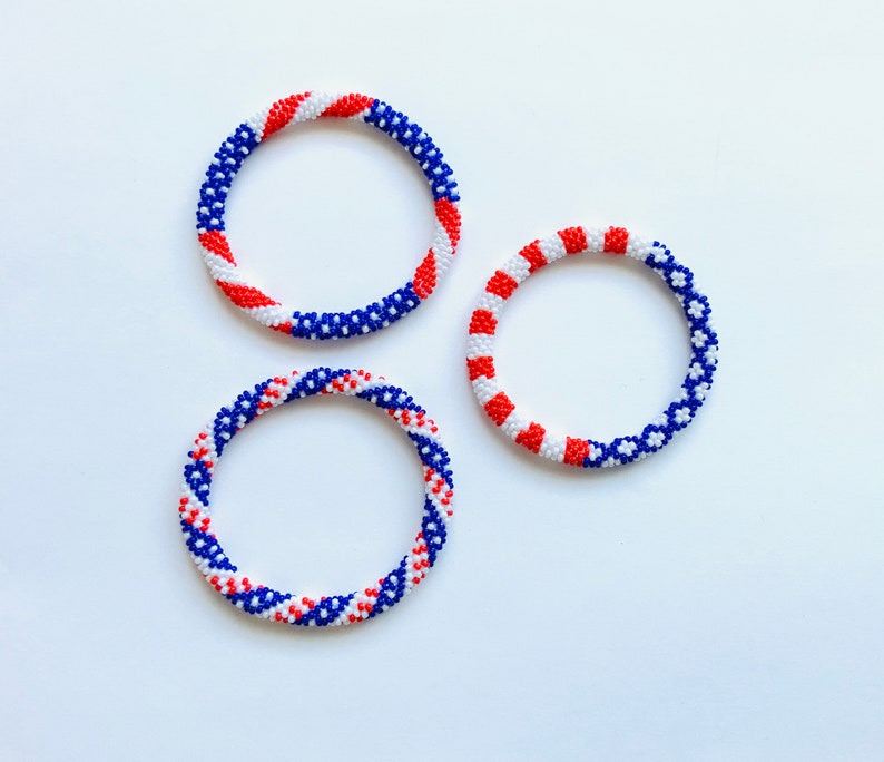 Puede incluir: Tres pulseras de cuentas en colores rojo, blanco y azul. Las pulseras est&aacute;n hechas de cuentas peque&ntilde;as y est&aacute;n tejidas en espiral.