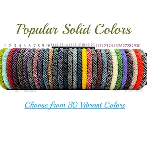 May include: Thirty colorful beaded bracelets in various solid colors, numbered 1 through 30. The bracelets are displayed on a black stand. The text "Popular Solid Colors" and "Choose from 30 Vibrant Colors" is displayed above and below the bracelets.