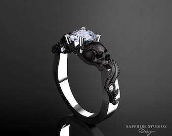 Puede incluir: Un anillo negro y plateado con un diseño de calavera y pulpo. El anillo presenta una gran piedra preciosa transparente en el centro.