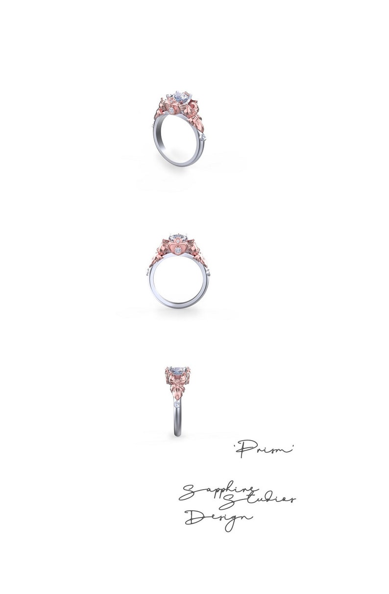Puede incluir: Un anillo de compromiso de plata y oro rosa con una piedra central grande y transparente y piedras m&aacute;s peque&ntilde;as en la banda. El anillo est&aacute; engastado con un dise&ntilde;o floral y las palabras 'Prism' y 'Sapphire Studies Design' est&aacute;n escritas debajo del anillo.