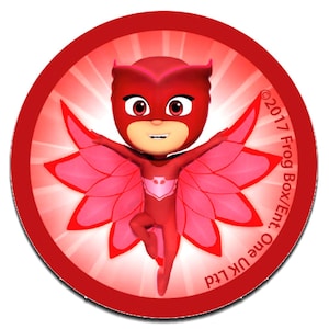 Könnte beinhalten: Ein runder Aufkleber mit der roten Figur Owlette aus PJ Masks mit ausgebreiteten Flügeln. Der Hintergrund ist leuchtend rot mit strahlenden Lichtstrahlen. Der Text 2017 Frog Box/Ent. One UK Ltd steht am rechten Rand.