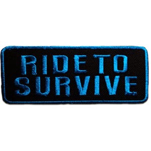 Op de afbeelding: Zwart rechthoekig embleem met de woorden "RIDE TO SURVIVE" geborduurd in helderblauw. De patch heeft een zwarte rand en is ontworpen om op kleding of accessoires te worden genaaid.