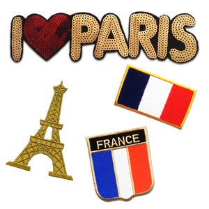 Puede incluir: Un conjunto de cuatro parches bordados que incluye el texto I heart PARIS en lentejuelas doradas, una Torre Eiffel dorada, una bandera francesa rectangular con borde amarillo y un parche en forma de escudo con la palabra FRANCE sobre la bandera.
