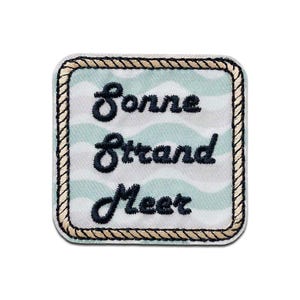 Könnte beinhalten: Quadratischer Aufnäher mit hellblau-weißem Wellenmuster. Der Aufnäher hat einen seilartigen Rand und einen dunkelblauen, gestickten Text mit der Aufschrift "Sonne Strand Meer".