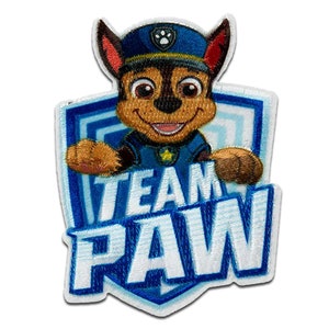 May include: A blue and white embroidered patch featuring a cartoon dog wearing a blue police hat. The dog is holding a sign that says "TEAM PAW".