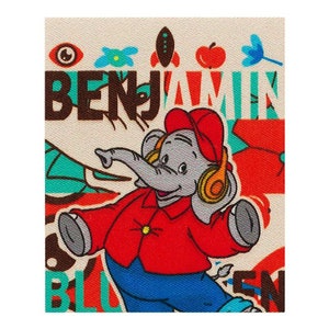 Op de afbeelding: Een kleurrijk patch met een cartoon-olifant die een rode hoed en koptelefoon draagt. De olifant draagt een rood jack, een blauwe spijkerbroek en danst. Het patch bevat het woord "BENJAMIN" in bruine letters.