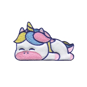 May include: Embroidered patch of a sleeping unicorn. The unicorn has a white body, pink muzzle and hooves, blue and yellow accents, and a blue horn. The patch is designed with a whimsical, cartoonish style.