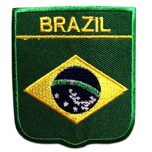 Könnte beinhalten: Ein grüner, gestickter Aufnäher mit dem Wort "BRAZIL" in gelben Großbuchstaben. Der Aufnäher zeigt die brasilianische Flagge: eine gelbe Raute mit einer blauen Kugel und weißen Sternen auf grünem Hintergrund.