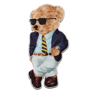 May include: A brown teddy bear wearing a blue blazer, a white shirt, a yellow and blue striped tie, white trousers, and brown shoes. The bear is wearing sunglasses and has a watch on its wrist.