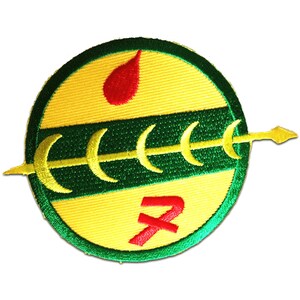 Könnte beinhalten: Ein runder, gestickter Aufnäher in Gelb und Grün mit einem roten Tropfen, einem roten X und einem grünen Pfeil mit goldener Spitze.
