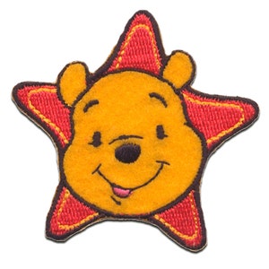 Pode incluir: Um remendo bordado com o rosto do Winnie the Pooh em forma de estrela vermelha.