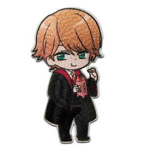 May include: Embroidered patch of a cartoon character wearing a black robe with a red and gold scarf, holding a box of snacks. The character has orange hair and green eyes.