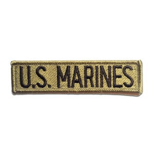 Könnte beinhalten: Rechteckiger, gestickter Aufnäher mit dem Text "U.S. MARINES" in schwarzer Schrift auf khakifarbenem Hintergrund. Der Aufnäher hat einen gestickten Rand und ist für Militäruniformen oder Kleidung geeignet.