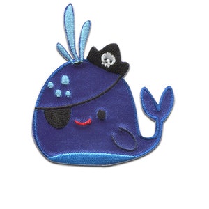 Könnte beinhalten: Blauer Wal-Aufnäher mit Piratenmotiv. Der Wal trägt einen schwarzen Piratenhut mit Totenkopf und gekreuzten Knochen sowie eine schwarze Augenklappe. Der Wal hat ein rotes Lächeln und blaue Akzente.