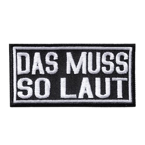 May include: Black rectangular patch with white embroidered text that reads "DAS MUSS SO LAUT". The patch has a white border and is likely designed to be sewn or ironed onto clothing or accessories.