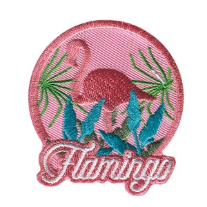 Pode incluir: Patch bordado com um flamingo rosa rodeado por folhagens verdes e turquesas. A palavra "Flamingo" é bordada em itálico na parte inferior. O patch tem um fundo rosa e uma borda costurada.