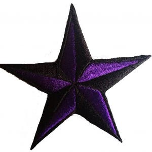 Può includere: Toppa ricamata a forma di stella a cinque punte, di colore viola e nero. La stella ha un design nautico con un centro viola scuro e punte nere.