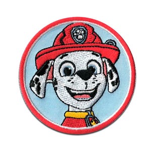 Peut inclure: Écusson brodé représentant un chien de dessin animé portant un chapeau et un uniforme de pompier rouges. Le chien a des taches noires et un visage souriant, sur fond bleu clair dans un cercle rouge. Pour vêtements ou accessoires.