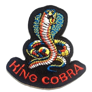 May include: Embroidered iron-on patch featuring a colourful king cobra with the text "KING COBRA" in red lettering on a black background.