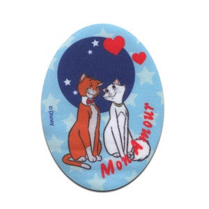 May include: An oval patch with a cartoon illustration of two cats, an orange one and a white one, facing each other. The background has a dark blue circle with stars, red hearts, and the text "Mon Amour". The Disney logo is visible.