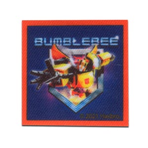 Könnte beinhalten: Quadratischer Aufnäher mit marineblauem Hintergrund und orangefarbenem Rand. Der Aufnäher zeigt das Wort "BUMBLEBEE" in weißen Blockbuchstaben über einer Grafik eines gelb-schwarzen Roboters. Der Text "© 2021 Hasbro" steht unten.