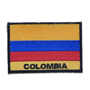 Può includere: Una toppa ricamata con i colori della bandiera colombiana, giallo, blu e rosso, con la scritta "COLOMBIA" in lettere nere.