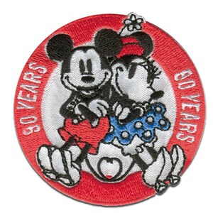 Pode incluir: Um remendo bordado vermelho e branco com Mickey Mouse e Minnie Mouse patinando no gelo. O remendo tem o texto "50 ANOS" e "SOUVENIRS" no anel externo.