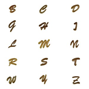 May include: A set of 26 cursive alphabet letters in varying shades of brown, displayed on a white background. The letters are arranged in rows and columns. The style of the letters suggests a handwritten appearance.