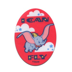 Könnte beinhalten: Ein roter ovaler Patch mit einem Cartoon-Bild von Dumbo dem Elefanten, der fliegt, mit dem Text "I CAN FLY" und einem Disney-Copyright-Symbol.