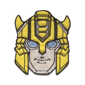 Könnte beinhalten: Gelber und schwarzer gestickter Aufnäher mit dem Gesicht von Bumblebee aus der Transformers-Franchise. Der Aufnäher zeigt einen gelben Helm mit schwarzen Streifen, blauen Augen und einem weißen Gesicht.