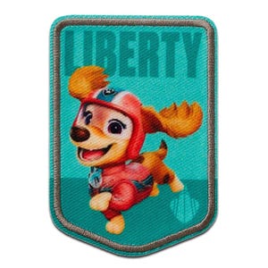 Op de afbeelding: Geborduurde patch met Liberty van Paw Patrol. De patch heeft een turquoise achtergrond met het woord "LIBERTY" in grote turquoise letters. Liberty is afgebeeld in een rood-roze outfit met een helm. De patch is rechthoekig met een gestikte rand.
