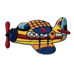 Könnte beinhalten: Gestickter Aufnäher eines bunten Flugzeugs mit rotem Propeller und rotem Stern auf dem Rumpf. Das Flugzeug hat gelbe, blaue, orange und rote Akzente. Das Design ist detailliert mit gestickten Linien.