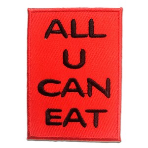 Könnte beinhalten: Roter Stoff-Patch mit schwarzem gesticktem Text, der "ALL U CAN EAT" lautet.