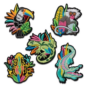 May include: Five colorful embroidered iron-on patches featuring a toucan, a monkey, a lizard, a frog, and an alligator. The patches are all on a white background.