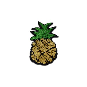 Può includere: Una toppa a forma di ananas gialla e verde fatta di paillettes. L'ananas è bordata di nero.