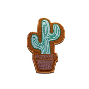 Puede incluir: Parche bordado con un cactus turquesa con detalles blancos en una maceta marrón, sobre un fondo marrón con un borde naranja. Diseñado para aplicar en ropa o accesorios.