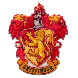 Peut inclure: Un écusson brodé représentant les armoiries de la maison Gryffondor de la série Harry Potter. L'écusson est rouge et or et comprend un lion, une épée et une bannière avec le mot "Gryffondor" dessus.