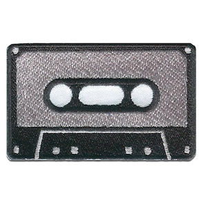 Op de afbeelding: Een geborduurde cassetteband patch in zwart en grijs. De band is grijs met witte cirkels en een zwarte omtrek. De cassettebehuizing is zwart met een grijze omtrek.