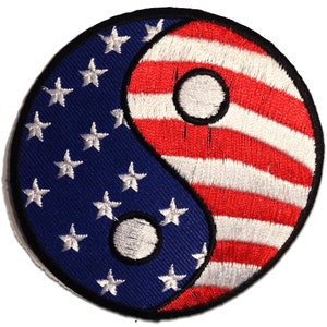 Puede incluir: Un parche bordado con un símbolo yin yang rojo, blanco y azul. El lado izquierdo del símbolo es azul con estrellas blancas, y el lado derecho es rojo con rayas blancas.