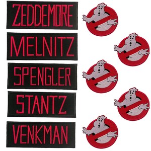 Może przedstawiać: Pięć czarnych prostokątnych łat z czerwonym haftem z tekstem "Zeddmore", "Melnitz", "Spengler", "Stantz" i "Venkman". Pięć czerwono-białych haftowanych łat z postacią ducha w symbolu zakazu.