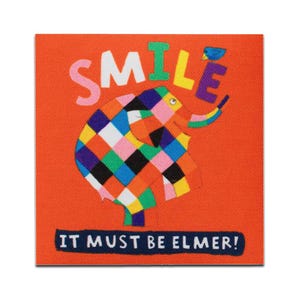 Könnte beinhalten: Ein bunter Patchwork-Elefant mit dem Wort "SMILE" in großen Buchstaben darüber. Der Text "IT MUST BE ELMER!" befindet sich unter dem Elefanten.