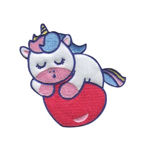 May include: An embroidered iron-on patch featuring a white unicorn with closed eyes, pink cheeks, and a blue mane and tail. The unicorn is lying on a red heart.