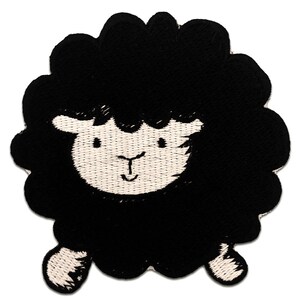 Può includere: Applique di pecora ricamata in nero con il viso bianco e la bocca sorridente.