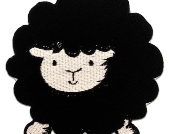 Pode incluir: Aplique de ovelha bordada em preto com o rosto branco e a boca sorridente.